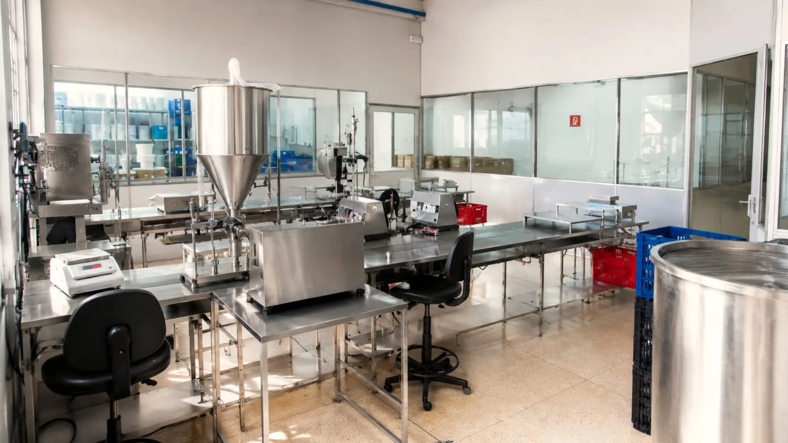 Linha de envase da fábrica Hibiscus — máquina de envase e bancadas de produção de cosméticos